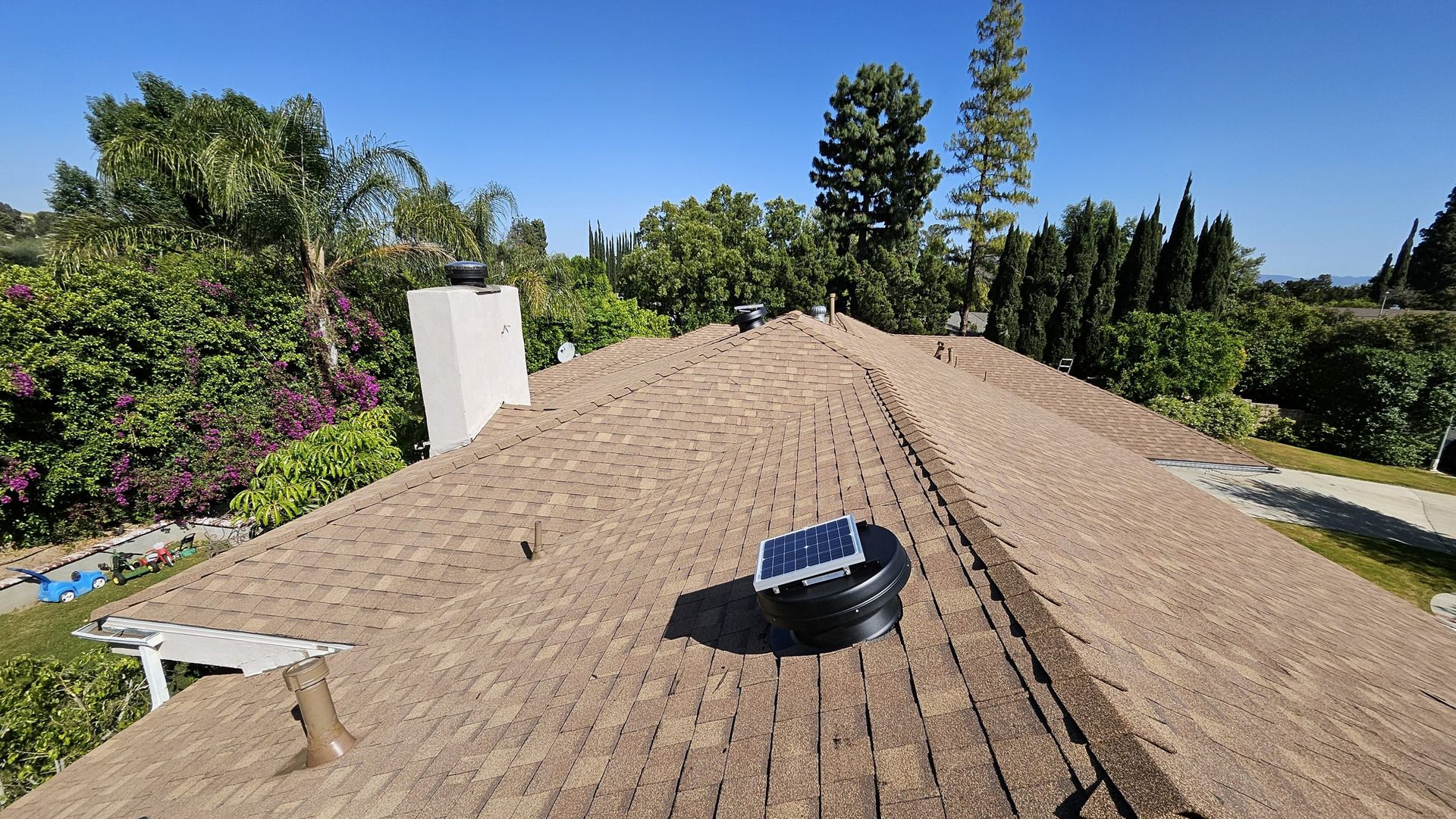 A roof with a chimney and a solar panel on it