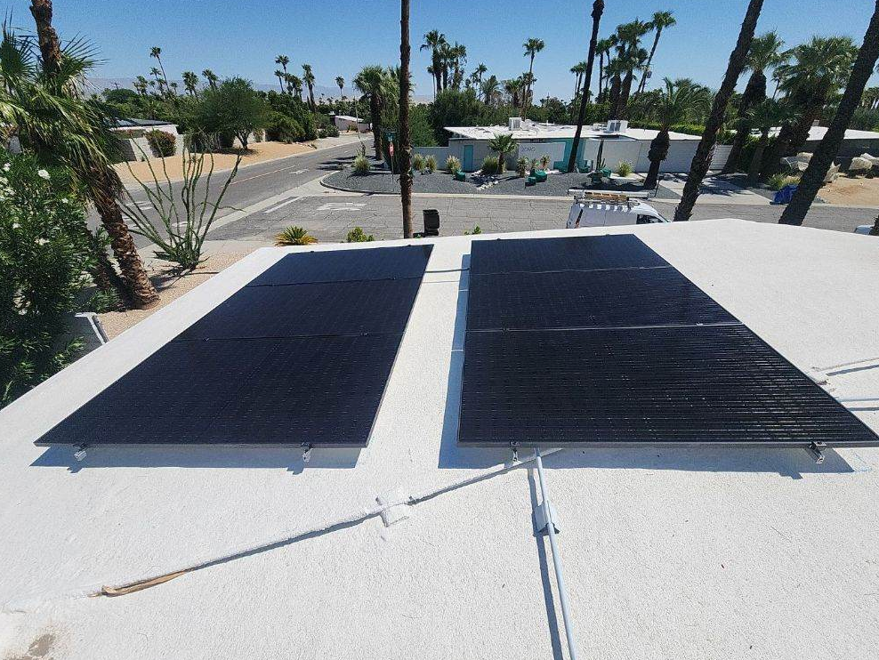 Two solar panels are sitting on top of a white roof