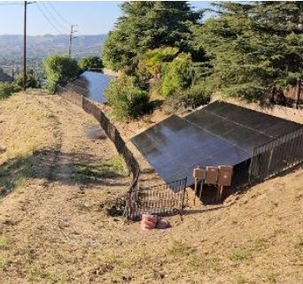 A row of solar panels are sitting on top of a hill.
