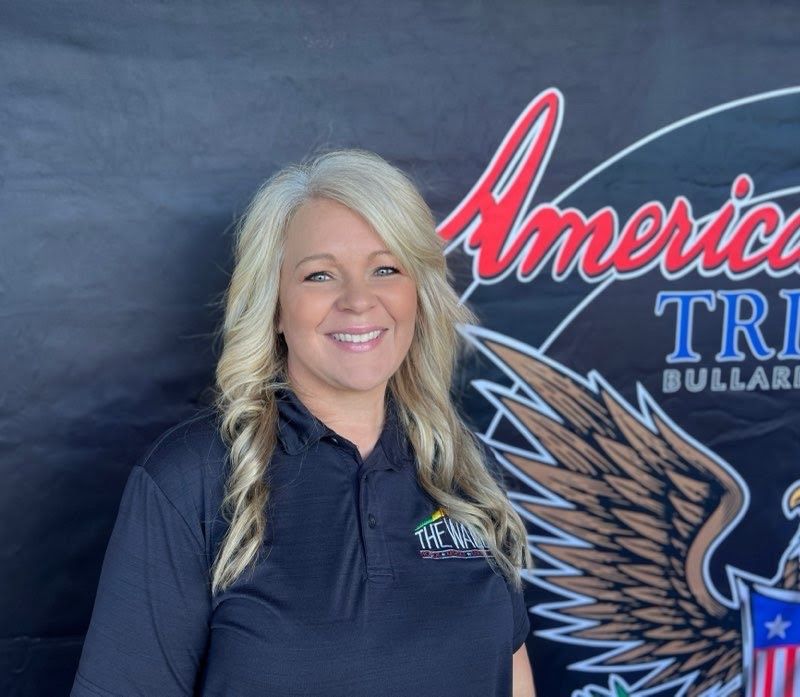 A woman is standing in front of a sign that says america tri billiards