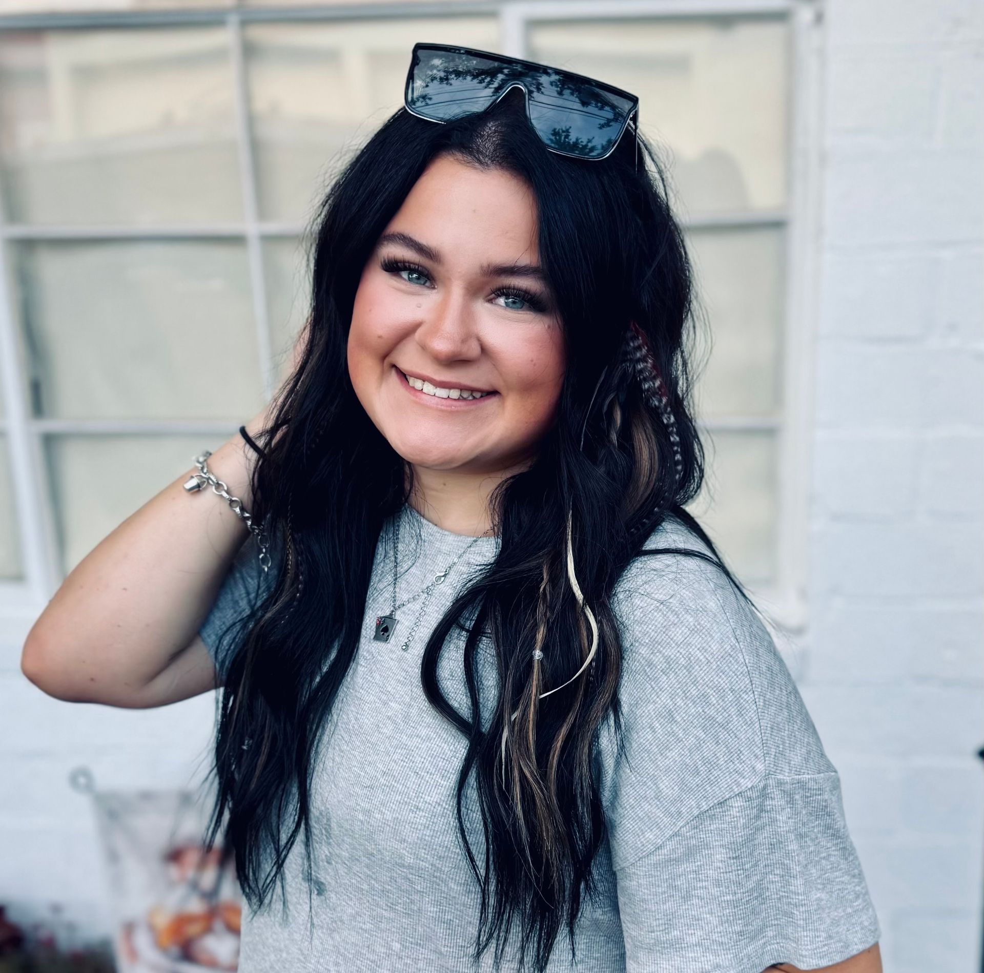 A man wearing a gray shirt that says the wall is smiling in front of a banner.
