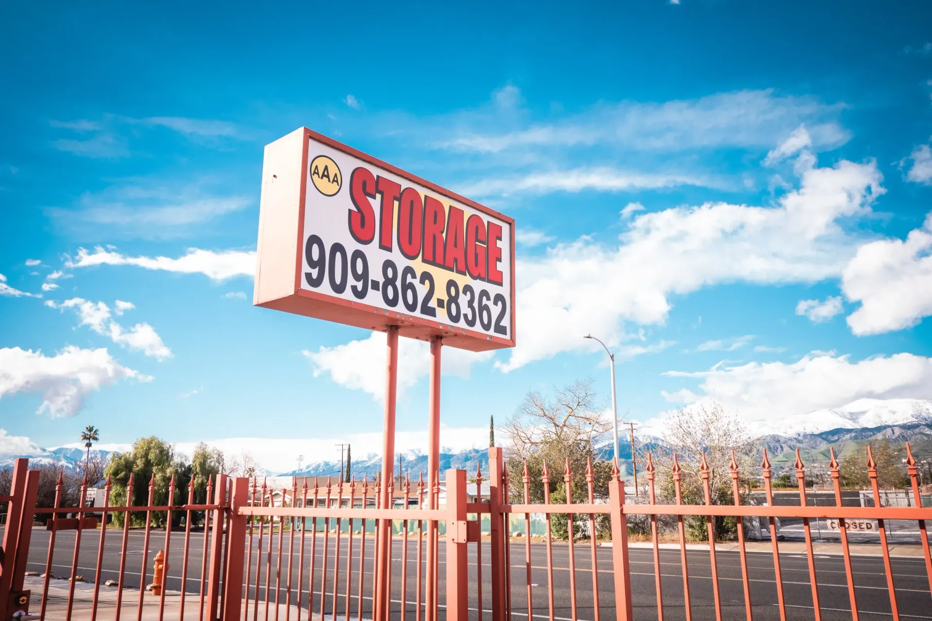 Hands locking a yellow storage unit with a padlock.