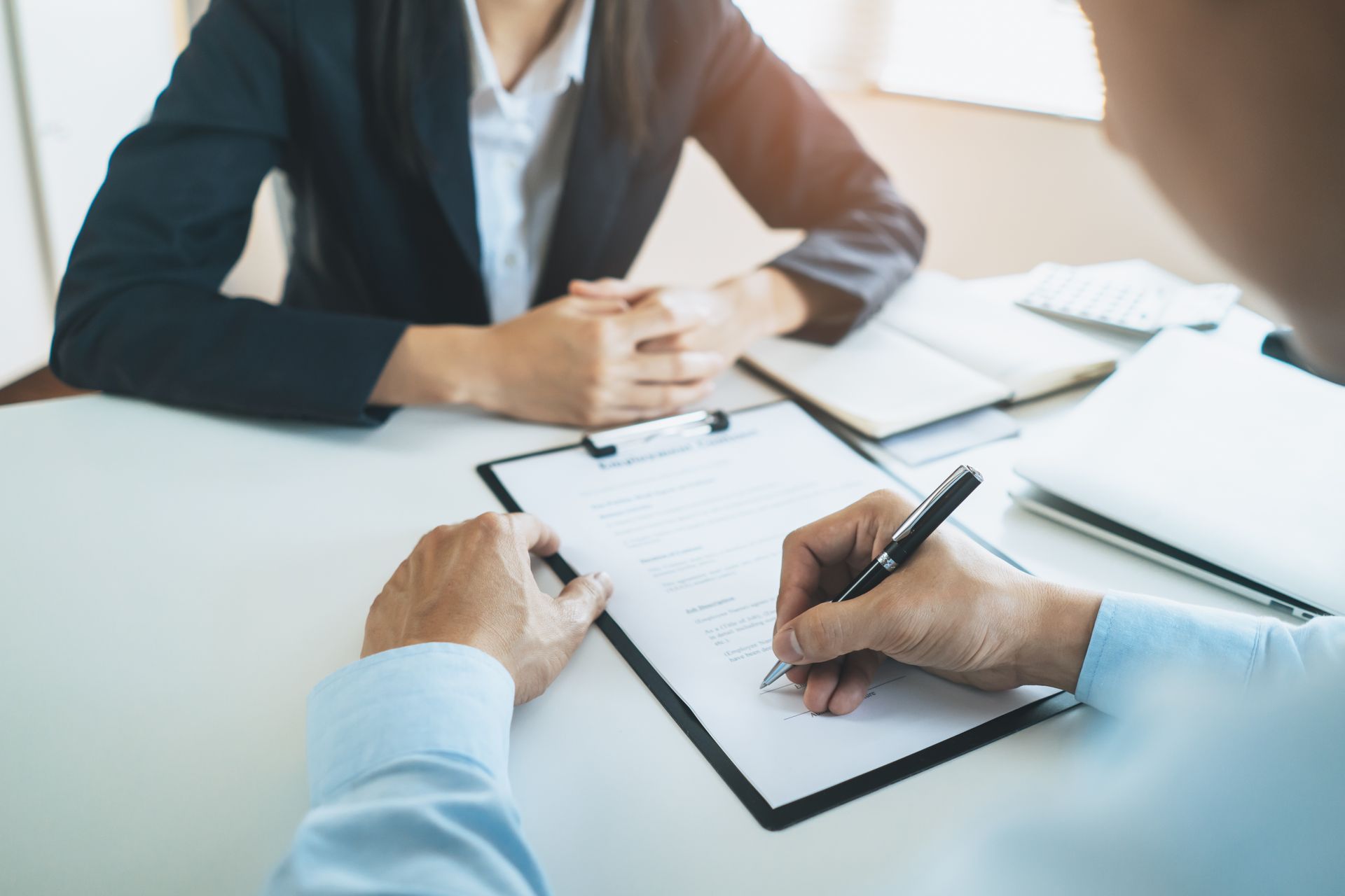 Attorney reviewing a written witness statement during a formal meeting with a client.