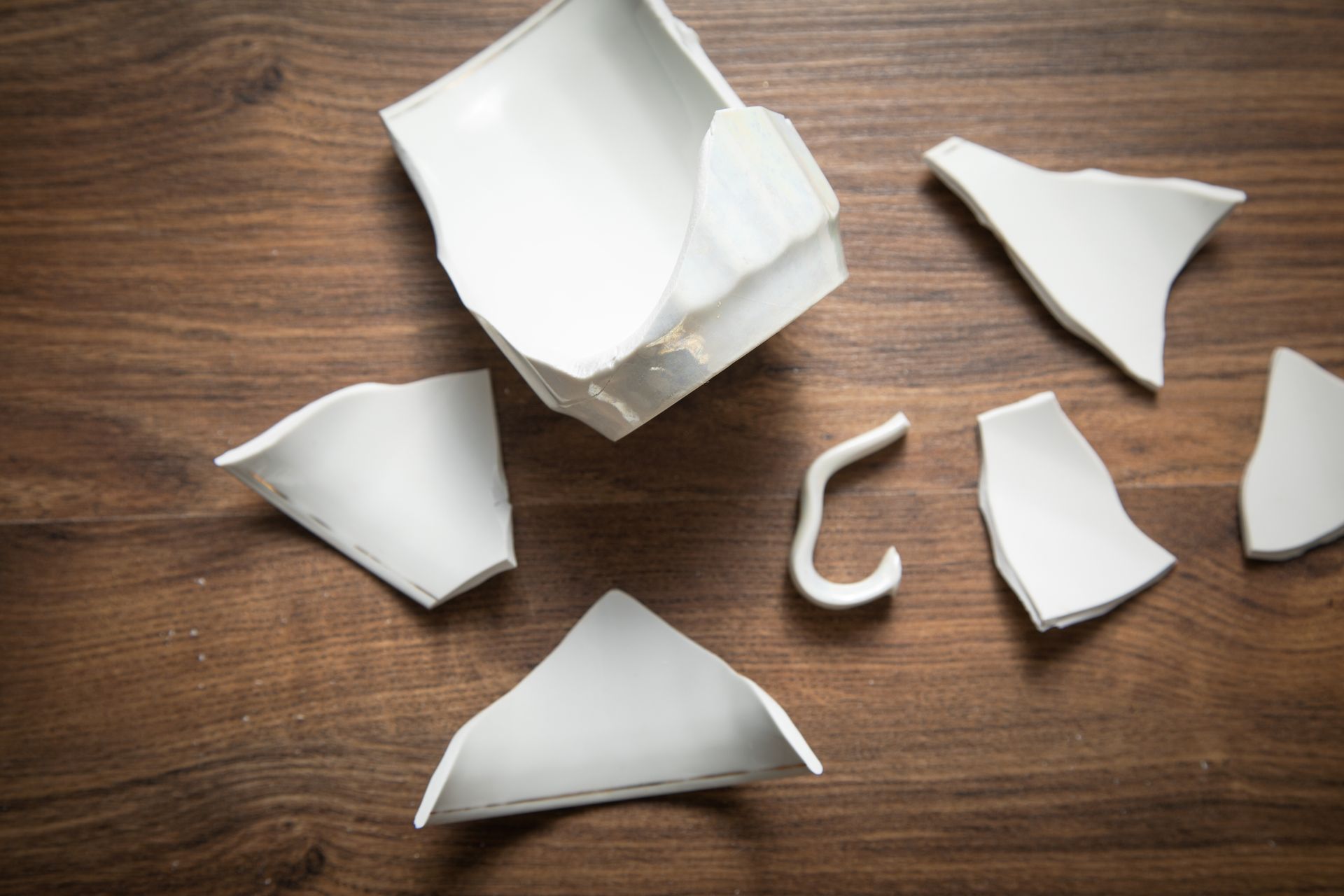A broken coffee mug on a wooden surface