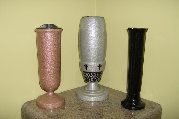 Three vases are sitting on a table in a corner.