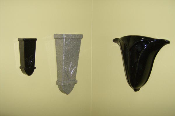 Three vases of different sizes are hanging on a wall