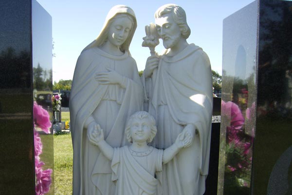 A statue of the holy family in a cemetery