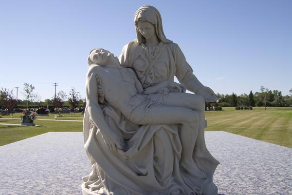 A statue of a woman holding a man laying on the ground