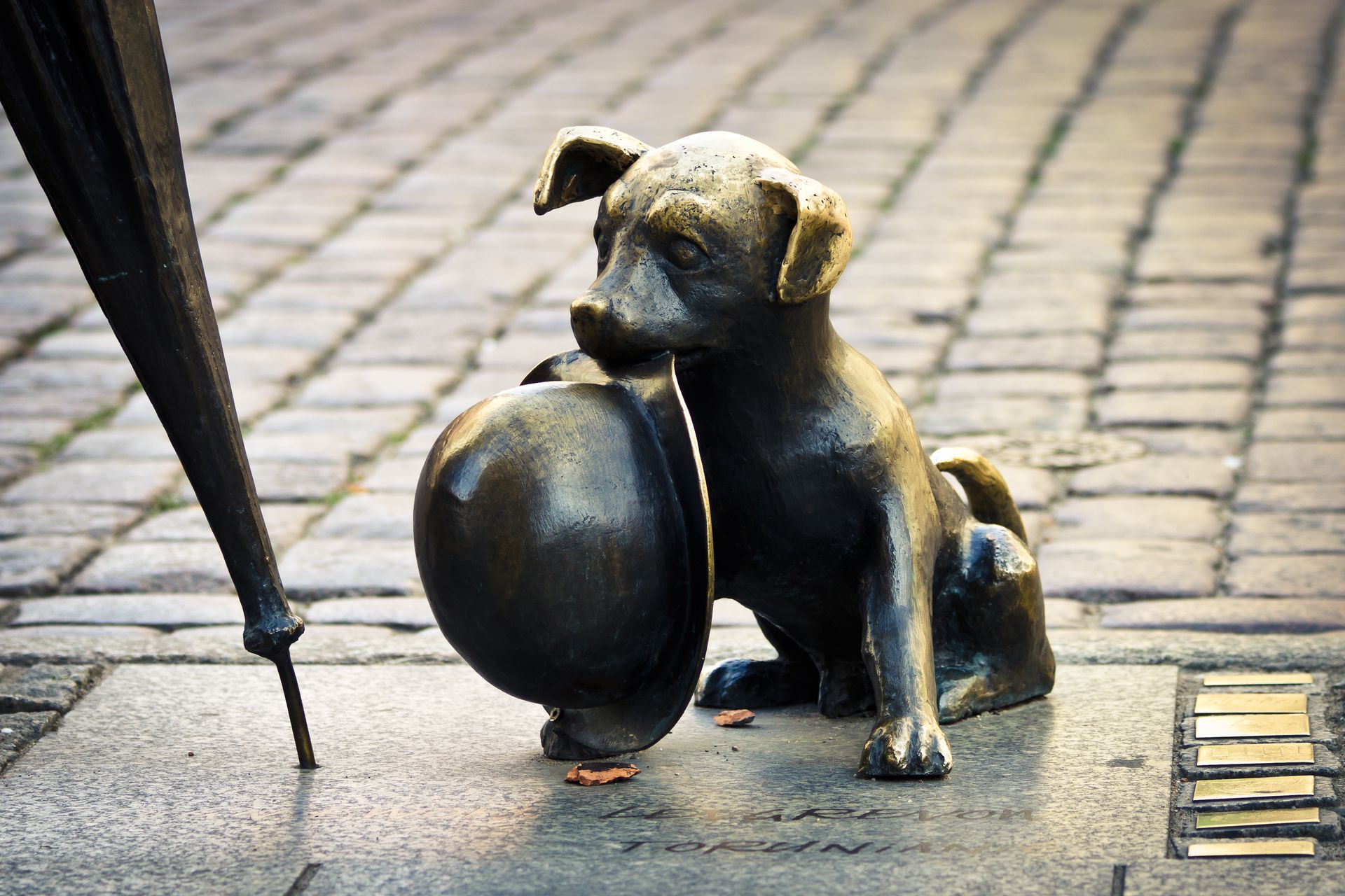 Dog statue holding hatwith umbrella