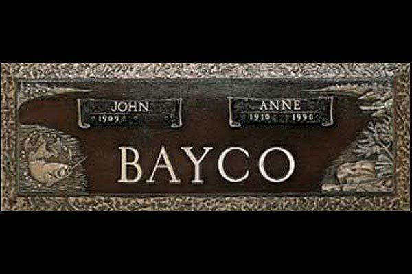 A gravestone for john and anne bayco with a fish on it.