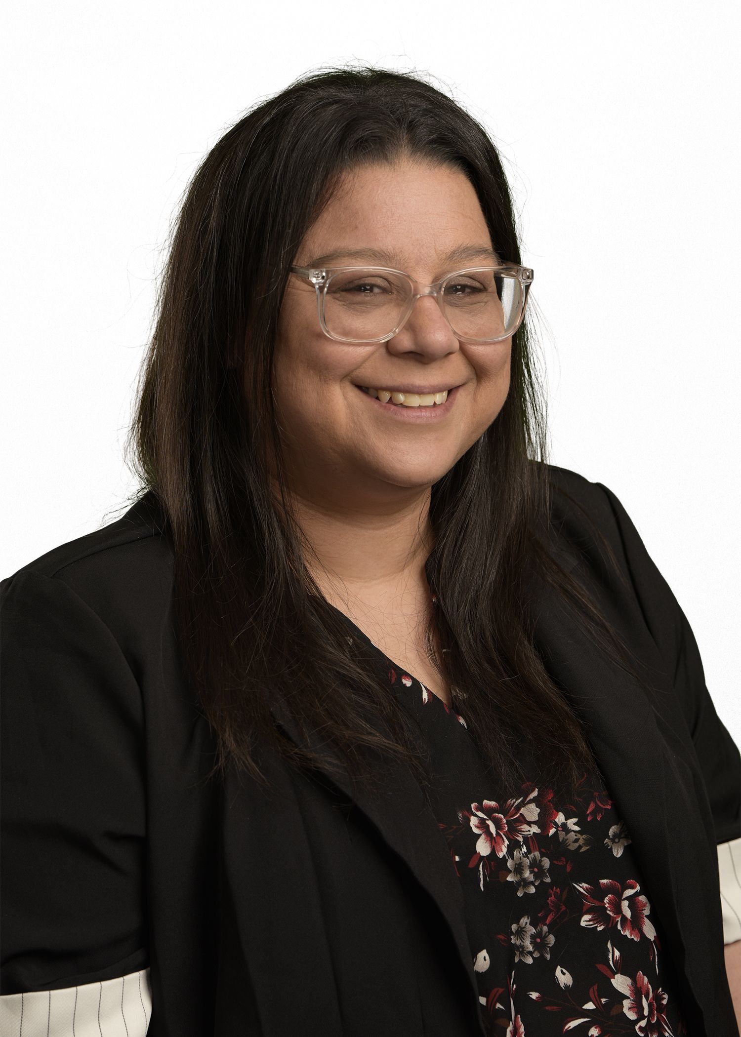 A woman wearing glasses and a green shirt is smiling for the camera.