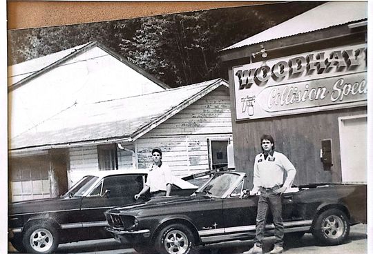 A black and white photo of two men standing in front of a building that says woodway