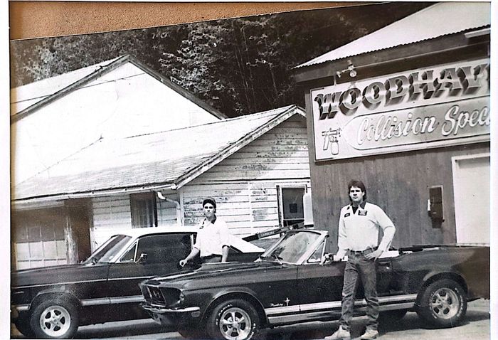 A black and white photo of two men standing in front of a building that says woodway