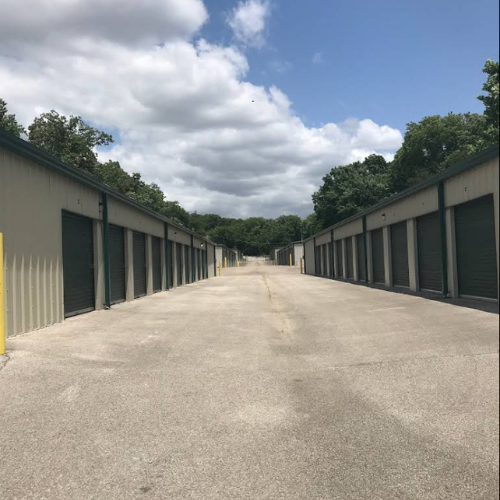 Rows of tall filing cabinets in a library storage area with a long, bright overhead light.
