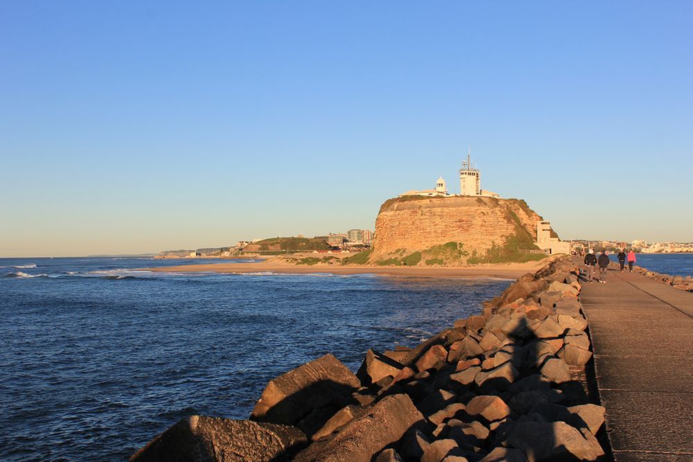 A Lighthouse On Top Of A Rocky Hill Overlooking The Ocean — Mark's Outboards & More In Newcastle, NSW