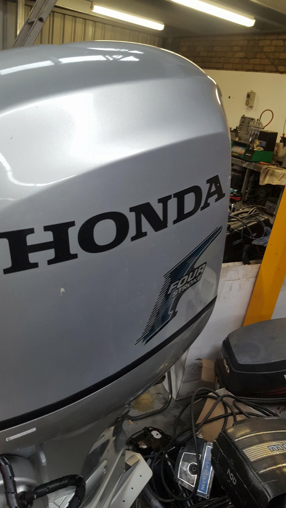 A Honda Outboard Motor Is Sitting In A Garage — Mark's Outboards & More In Central Coast, NSW