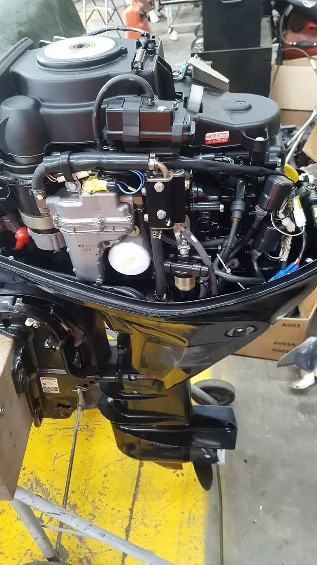 A Boat Engine Is Sitting On The Ground In A Warehouse — Mark's Outboards & More In Muswellbrook, NSW