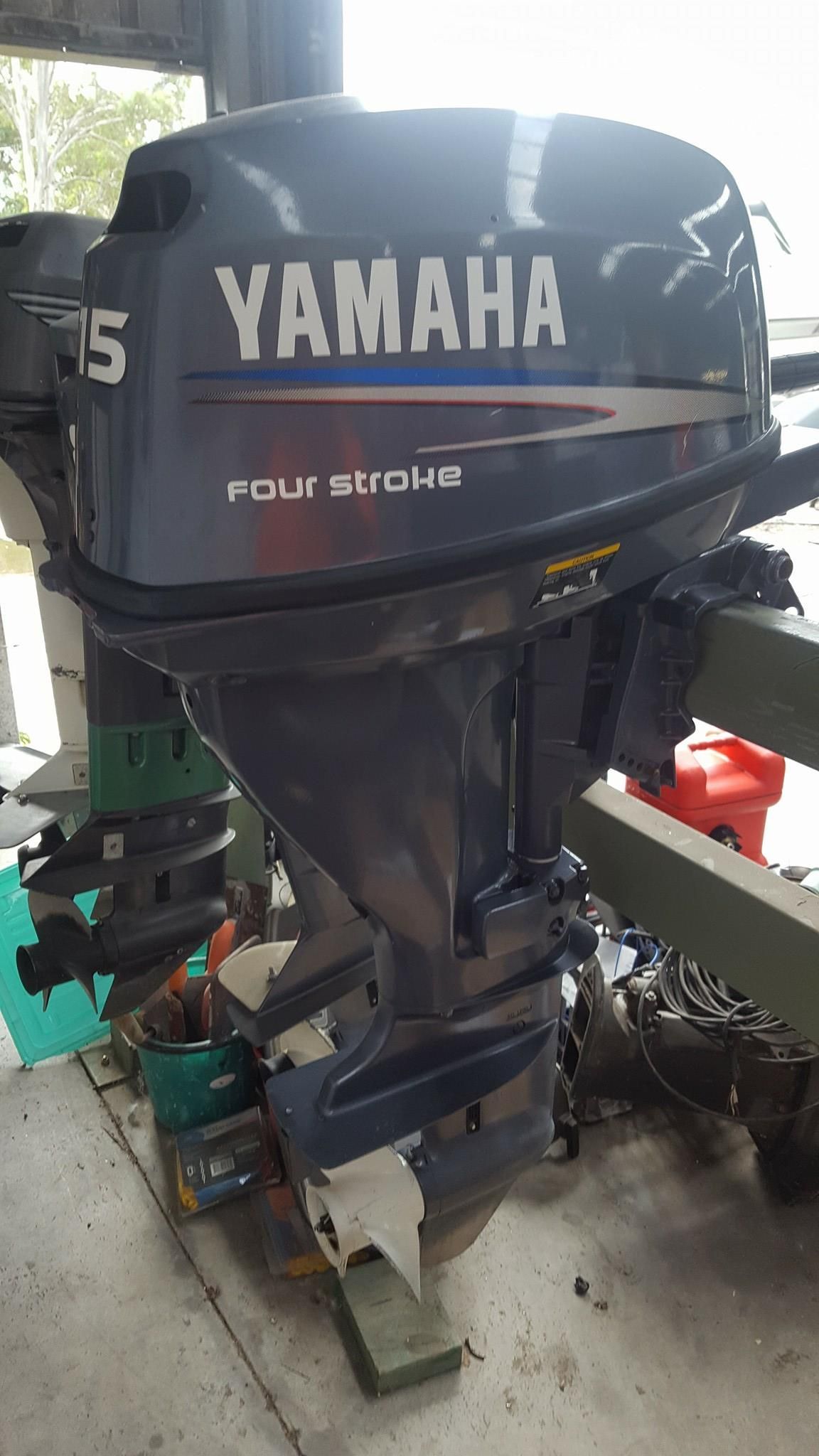 A Yamaha Outboard Motor Is Sitting On The Ground In A Garage — Mark's Outboards & More In Central Coast, NSW
