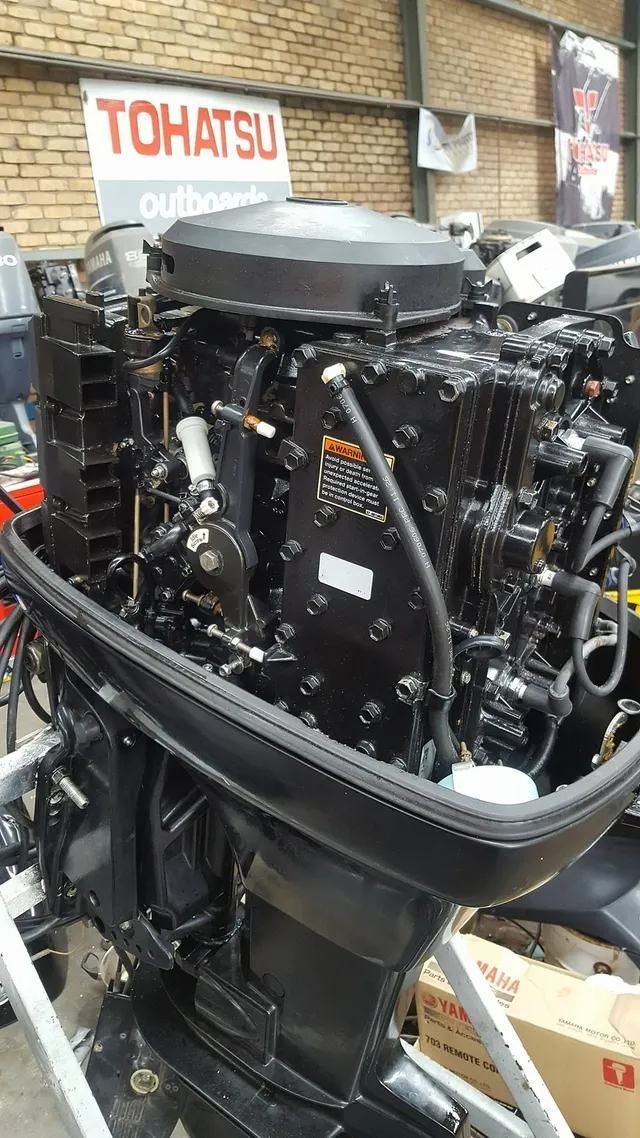 A Black Outboard Motor Is Sitting In A Warehouse — Mark's Outboards & More In Muswellbrook, NSW