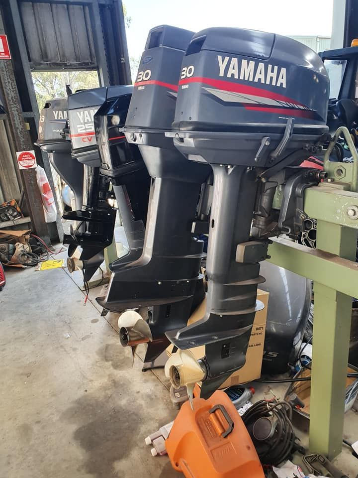 A Row Of Yamaha Outboards Are Sitting In A Garage — Mark's Outboards & More In Central Coast, NSW