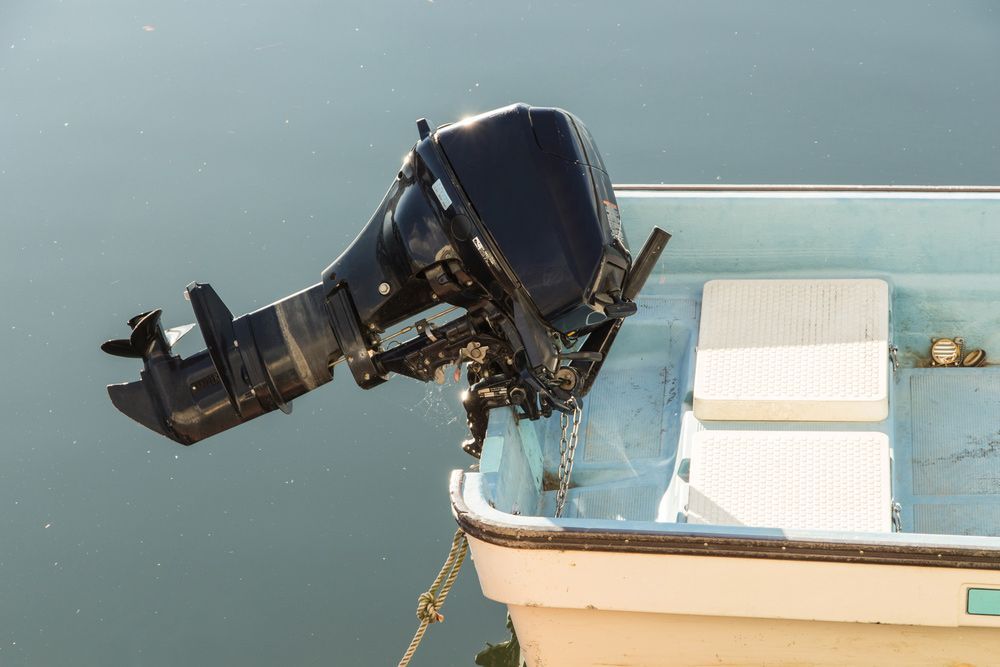 An Outboard Motor Is Attached To The Side Of A Small Boat — Mark's Outboards & More In Cessnock, NSW