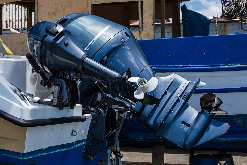 A Blue Outboard Motor Is Sitting On The Side Of A Boat — Mark's Outboards & More In Cessnock, NSW
