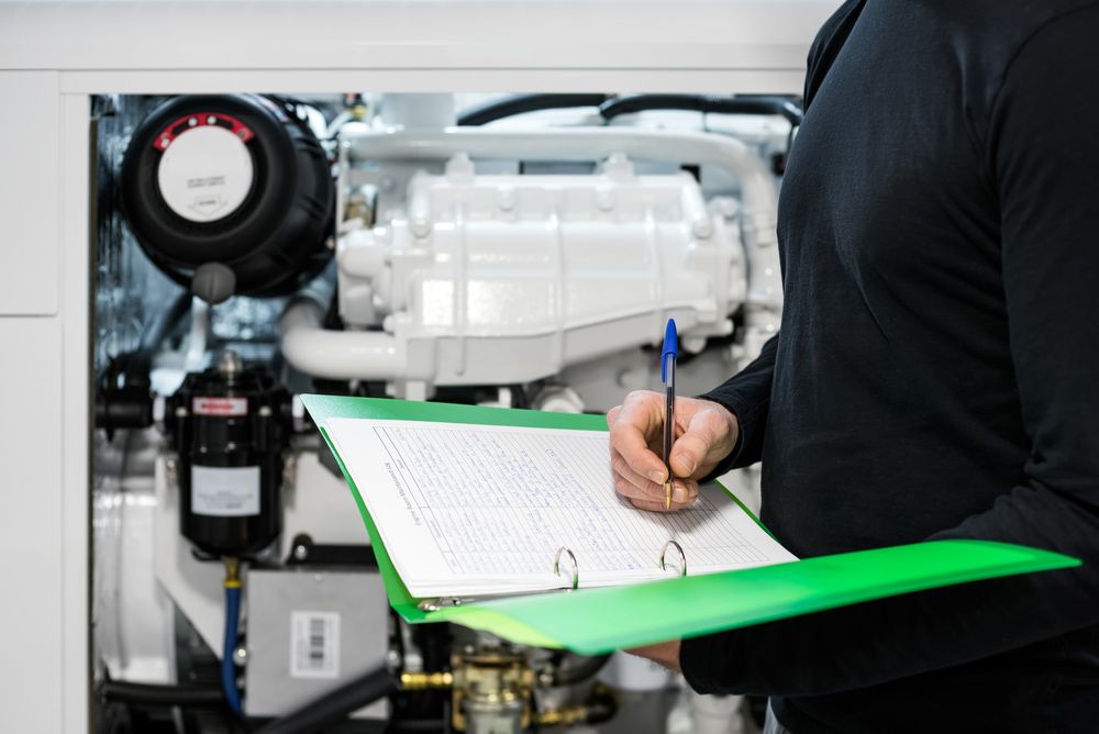 A Man Is Writing On A Clipboard In Front Of A Boat Engine — Mark's Outboards & More In Port Stephens, NSW