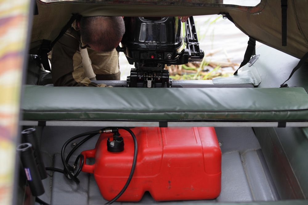 A Red Gas Can Sits Under A Boat Motor — Mark's Outboards & More In Port Stephens, NSW