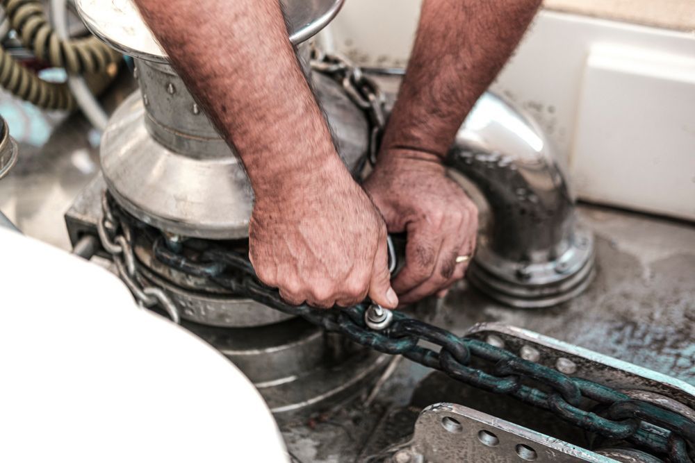 A Man Is Fixing A Chain On A Boat — Mark's Outboards & More
In Lake Macquarie, NSW