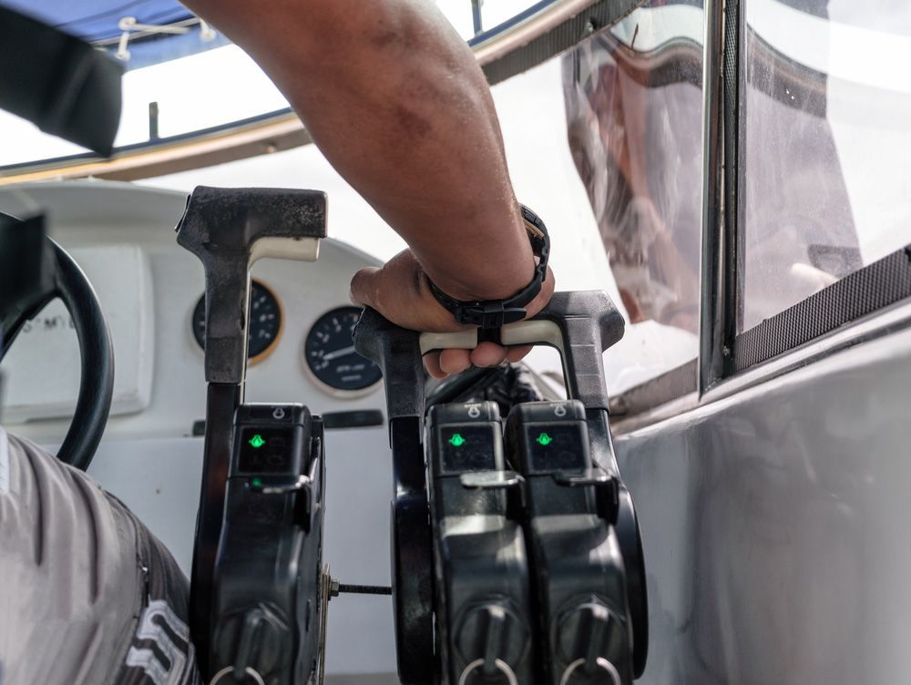 A Man Is Holding The Steering Wheel Of A Boat — Mark's Outboards & More In Lake Macquarie, NSW