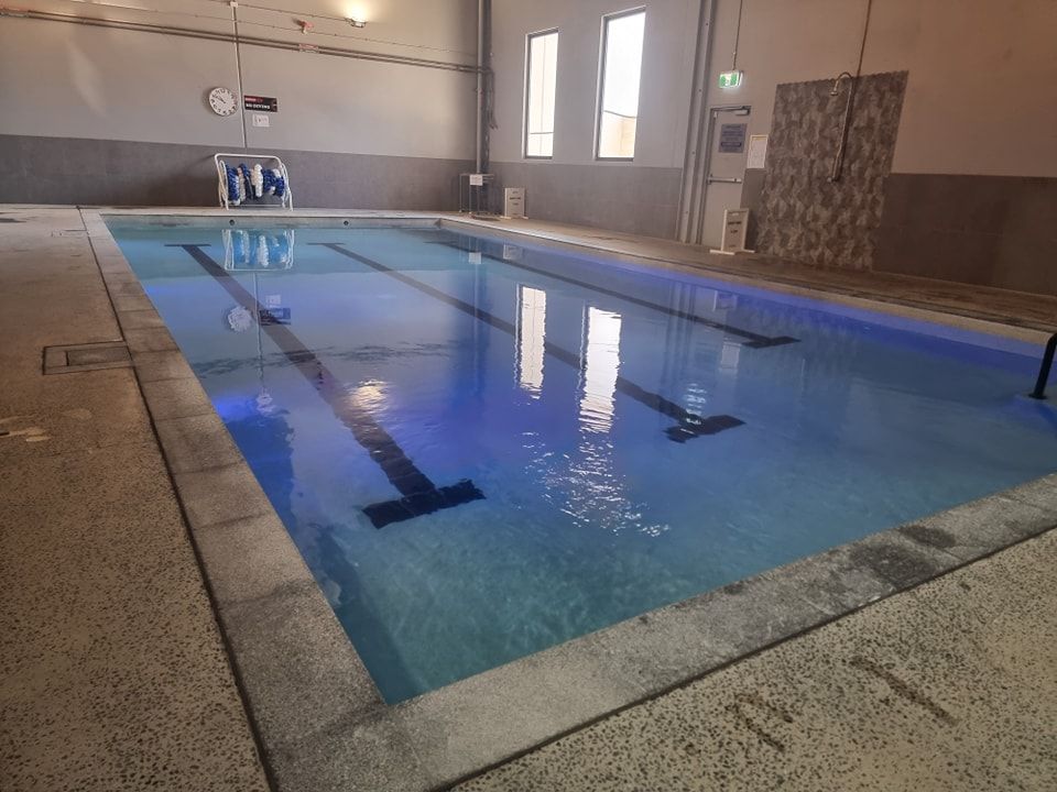 A Large Indoor Swimming Pool With Blue Lights on It — DNA Aquatics in Bundaberg, QLD