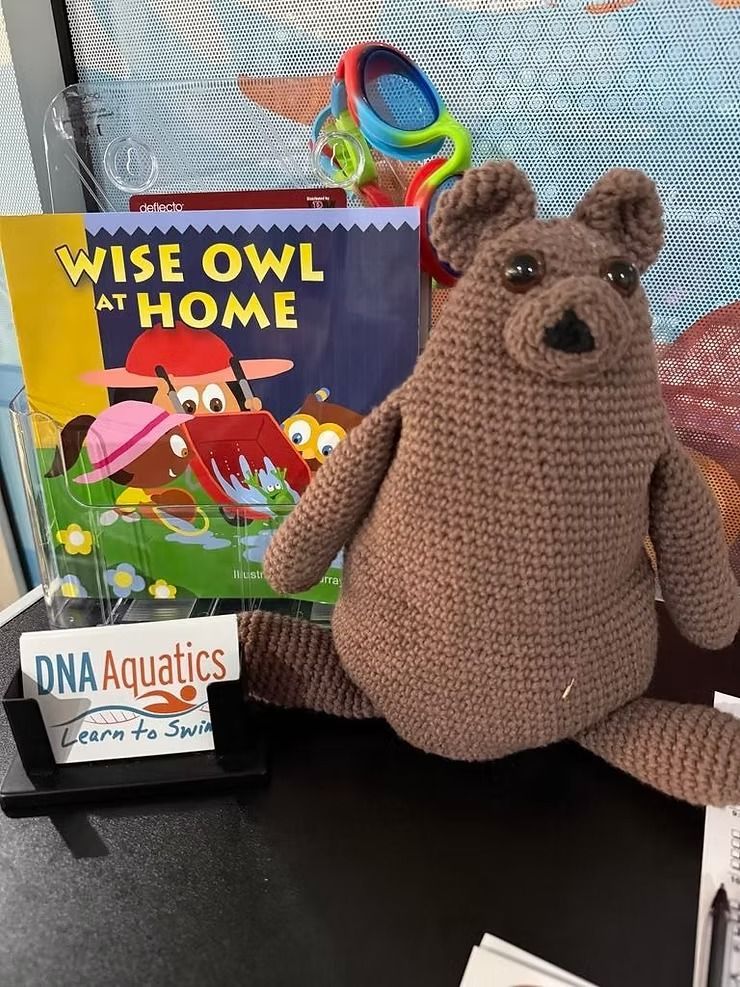 A Stuffed Bear is Sitting in Front of a Book — DNA Aquatics in Bundaberg, QLD