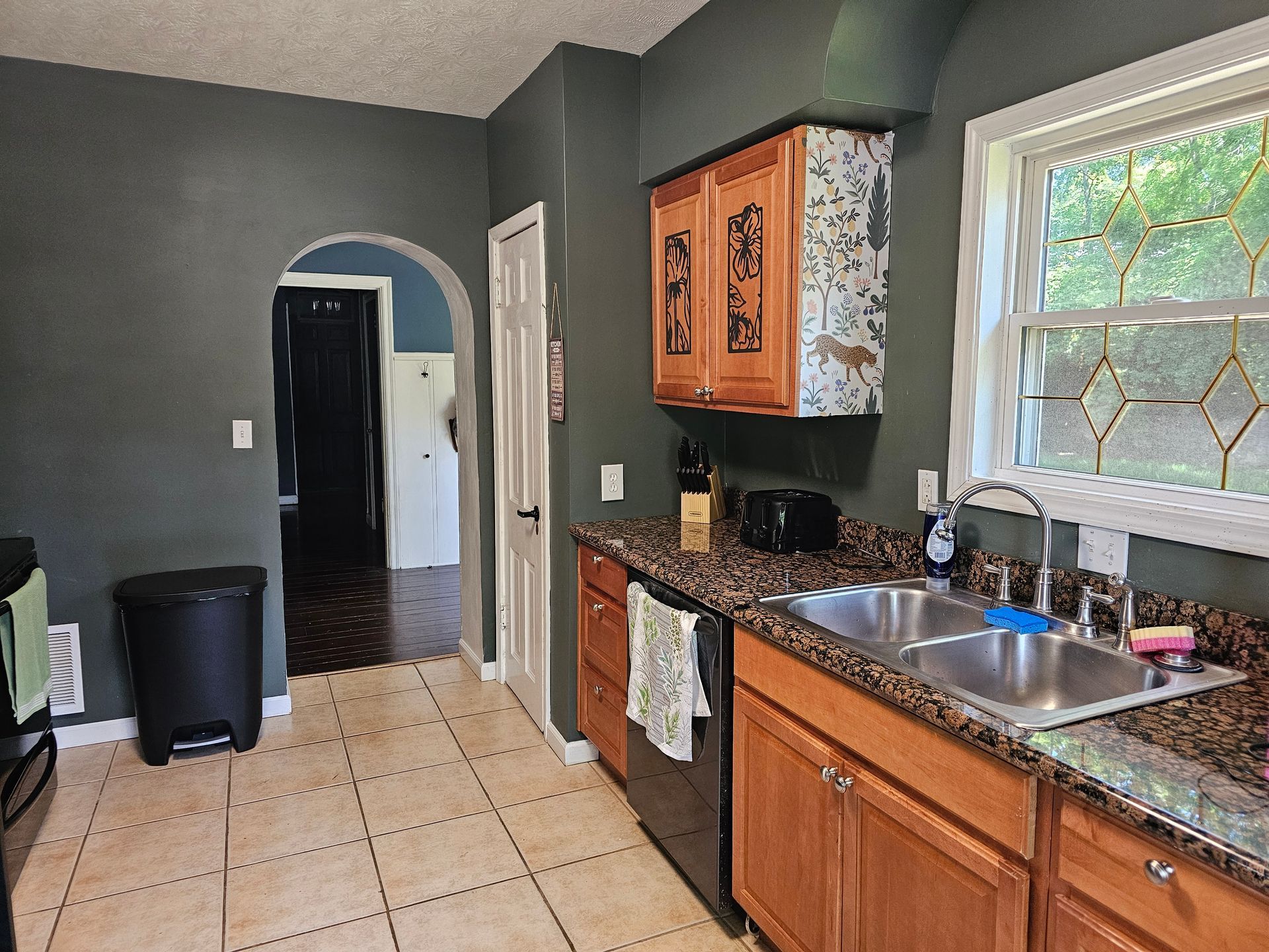 A kitchen with wooden cabinets and a stainless steel sink