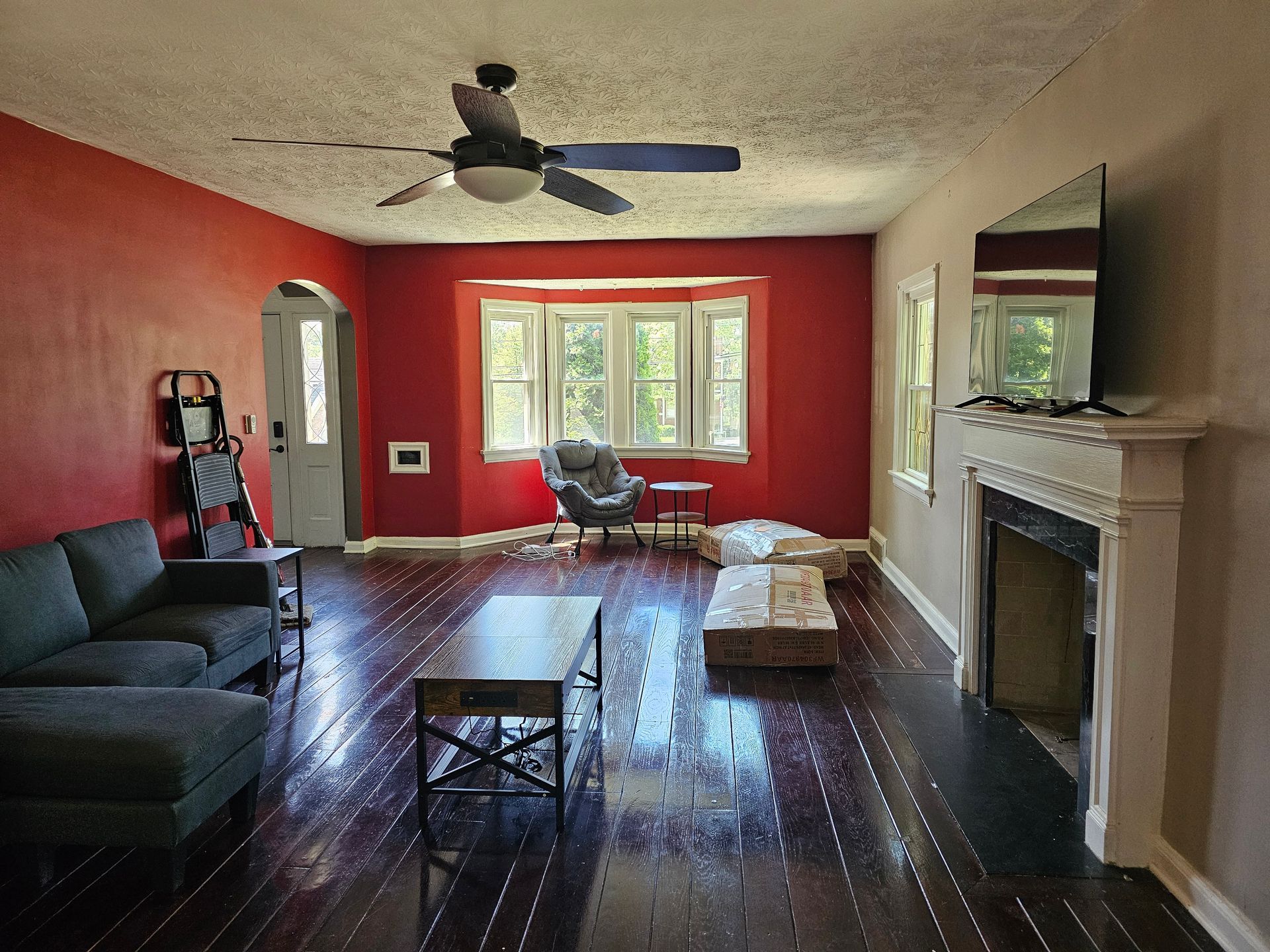 A living room with red walls and a fireplace
