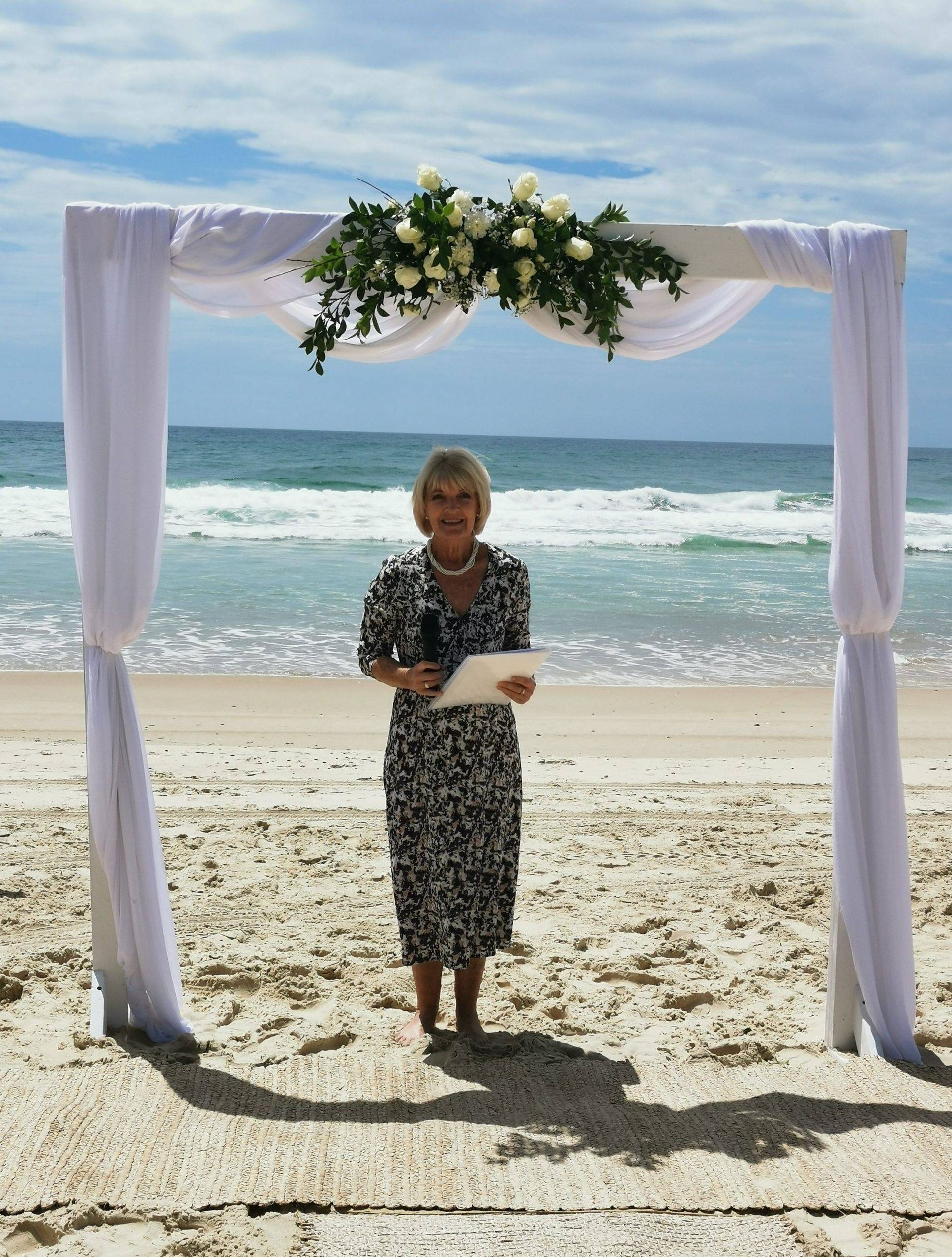 A Bride and Groom Are Kissing on A Dock Next to A Lake — Vivienne Celebrant - Gold Coast Wedding Celebrant in Casuarina, NSW