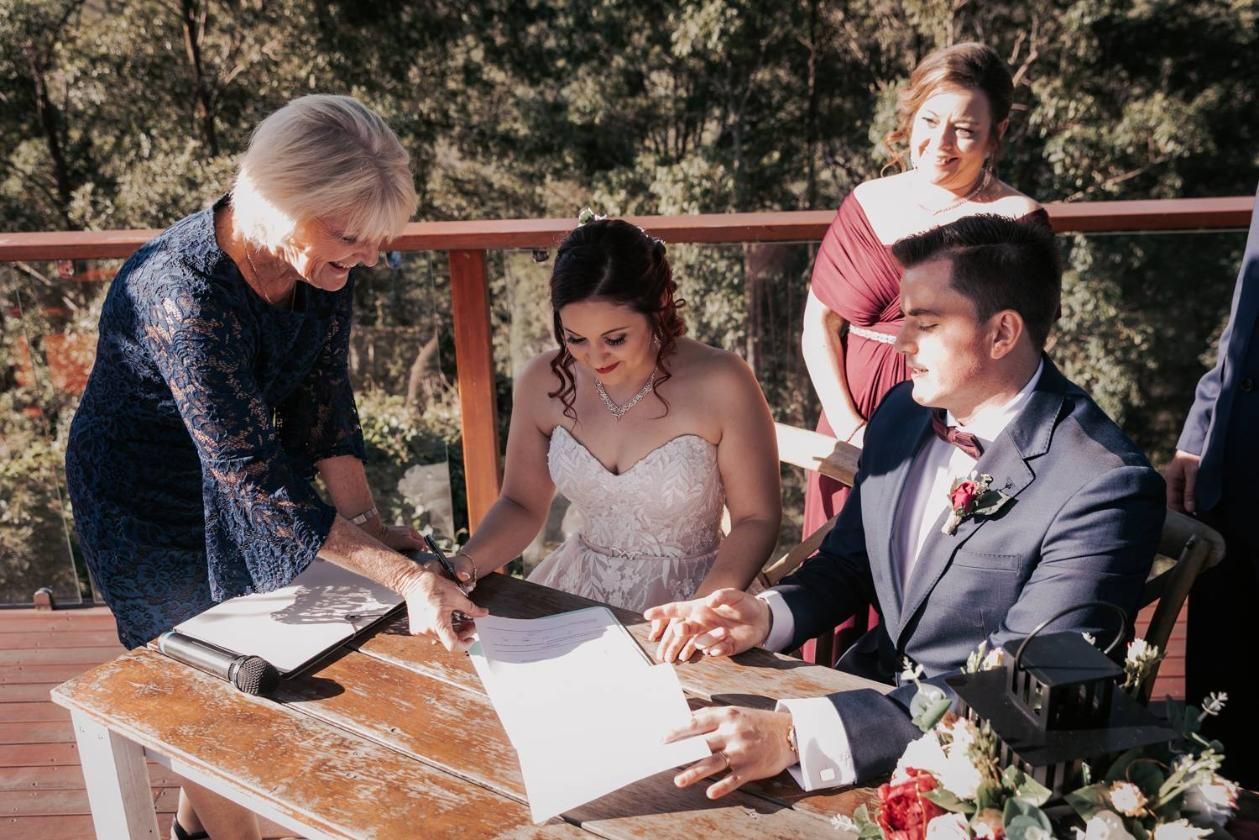 A Bride and Groom Are Signing a Wedding Certificate — Vivienne Celebrant - Gold Coast Wedding Celebrant in Casuarina, NSW