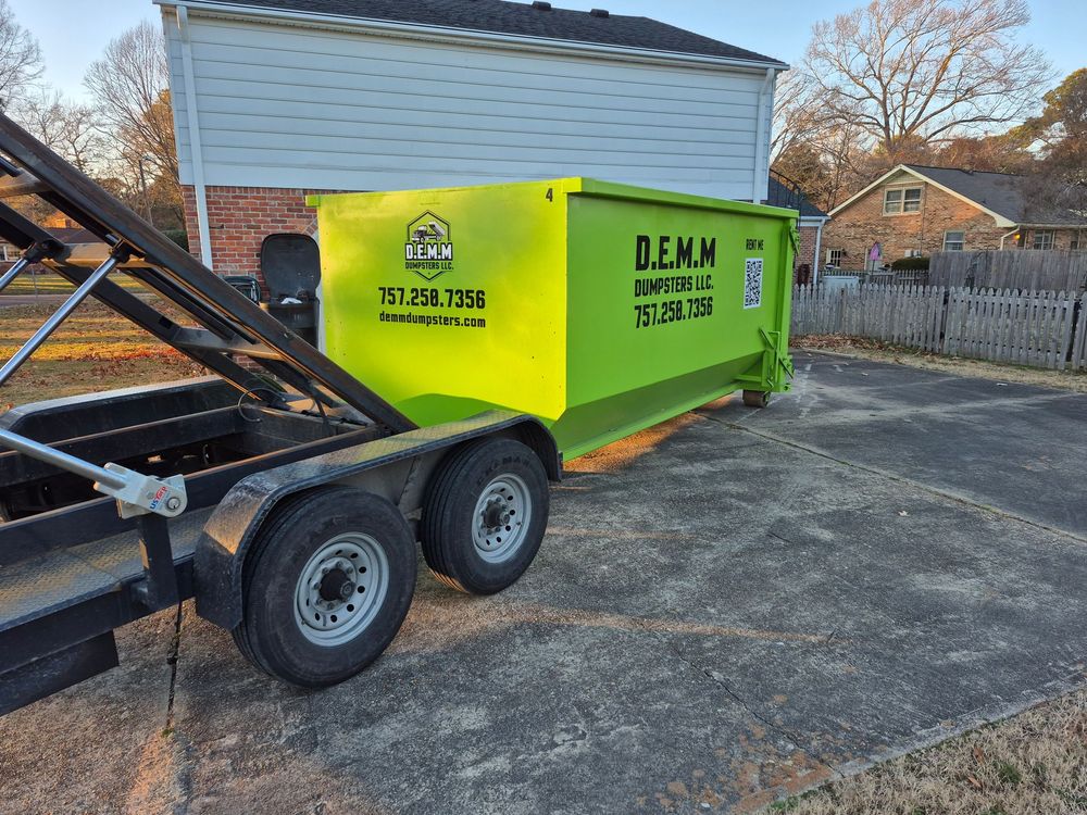 Construction dumpster filled with wood, shingles, and insulation from a Hampton Roads jobsite