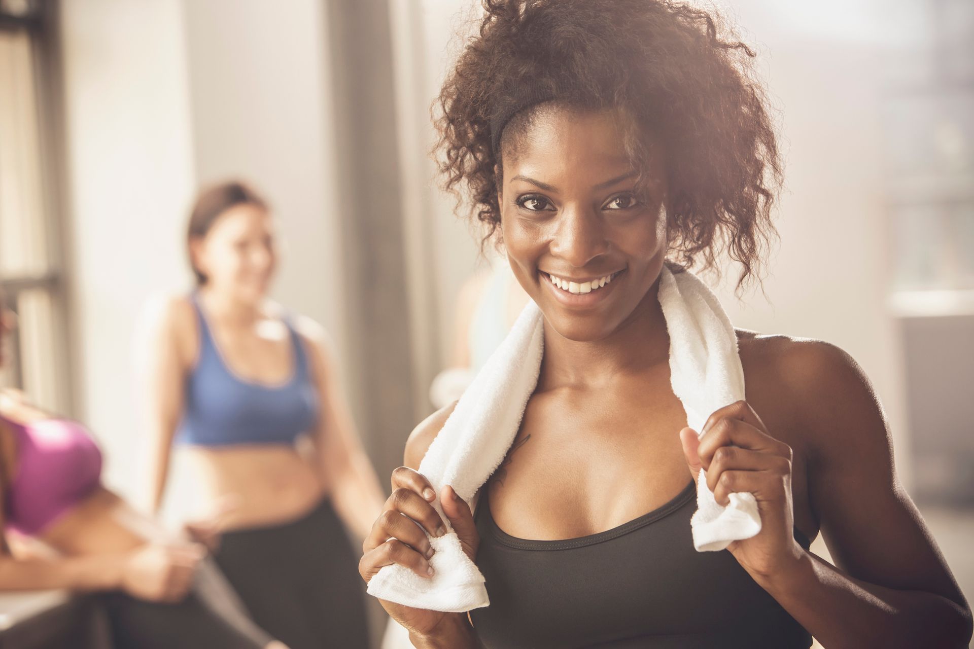 Woman happy in gym setting, highlighting fitness journey with hormone therapy benefits. Woman happy in gym setting, highlighting fitness journey with hormone therapy benefits.