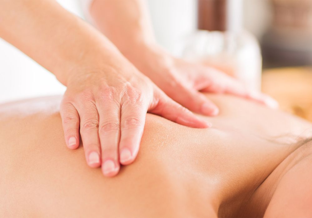 Top View Of Beautiful Young Woman Lying On Front With Spa Stones On Her Back