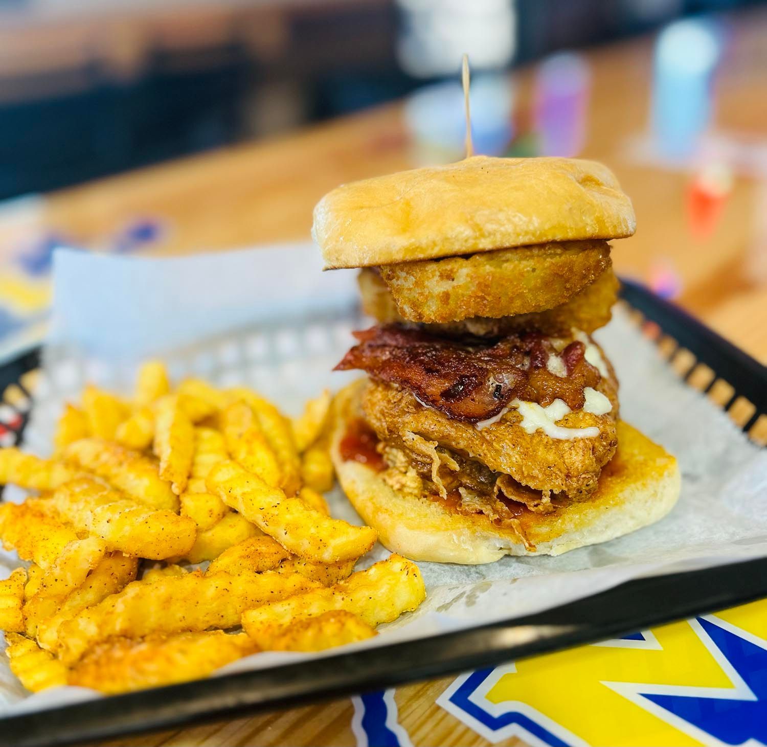 A sandwich and french fries are on a tray on a table.