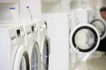 A row of white front load washing machines