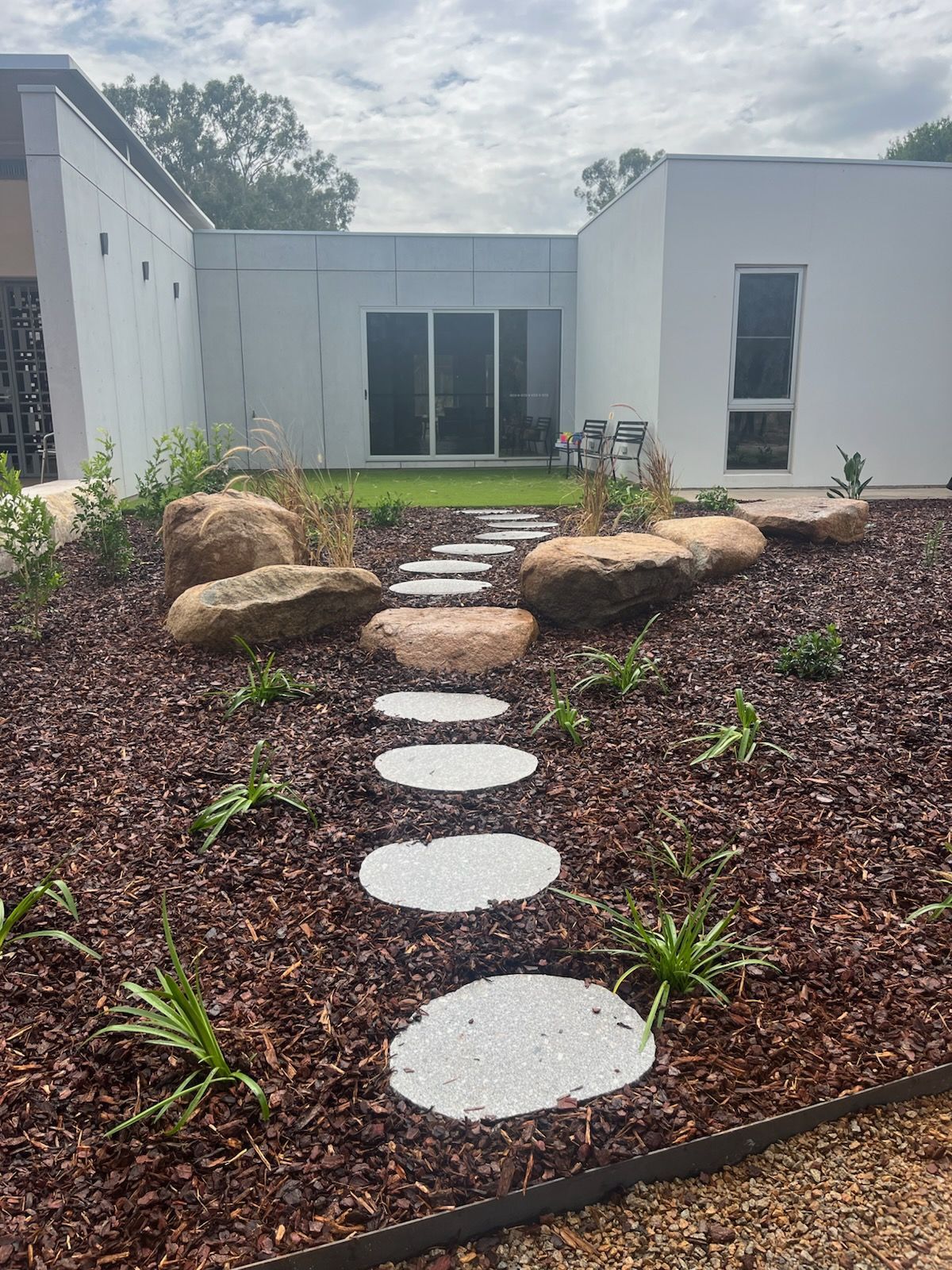Stone path through a landscaped yard with rocks and plants — Dubbo Premier Landscapes in Dubbo, NSW