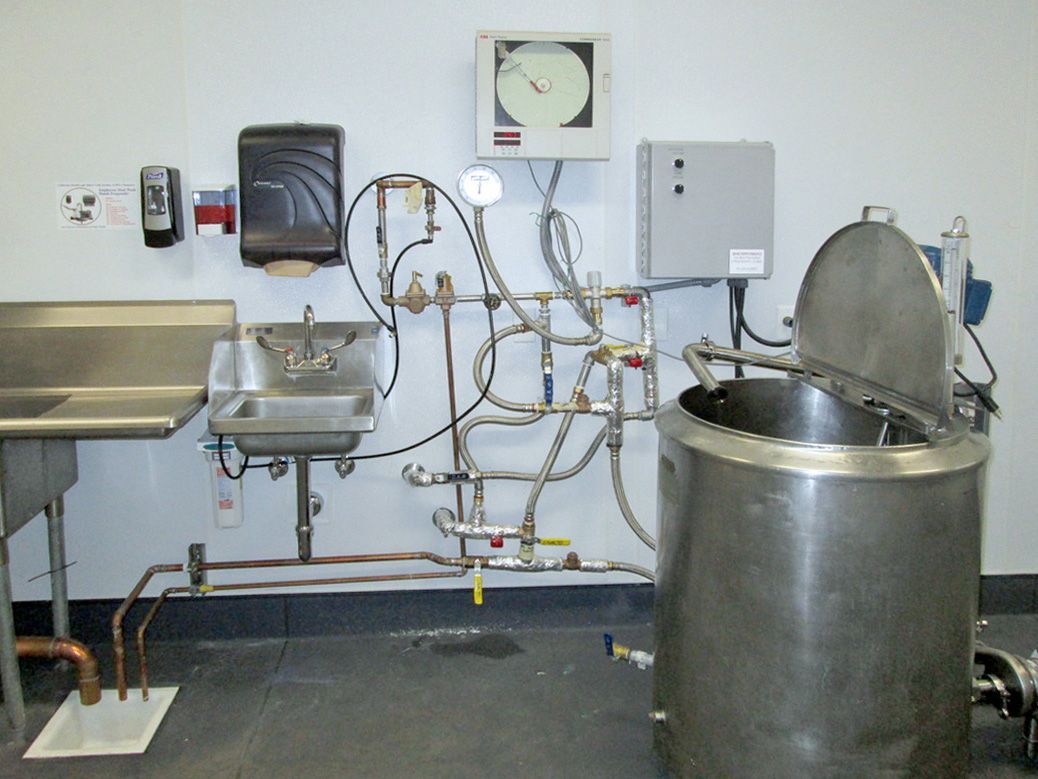 A kitchen with a sink and a clock on the wall