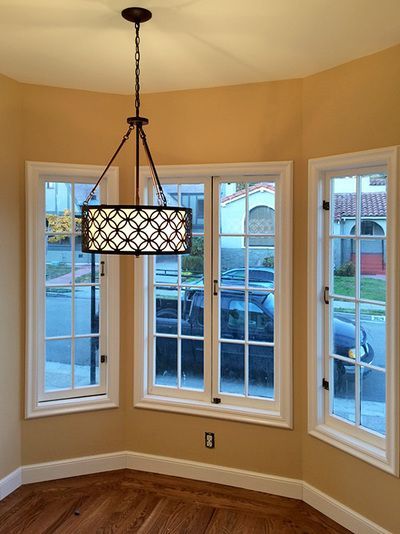 A room with lots of windows and a chandelier hanging from the ceiling