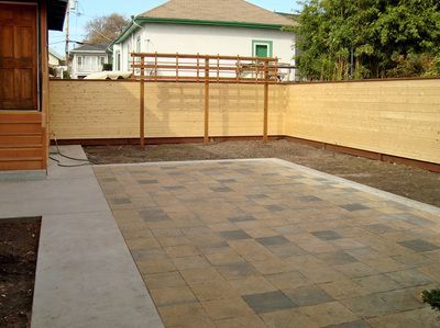 A backyard with a wooden fence and a patio