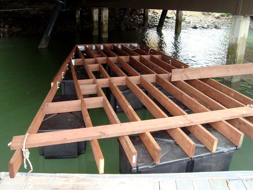 A wooden deck is being built in the water under a bridge