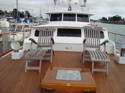 A boat with two chairs and a table on the deck