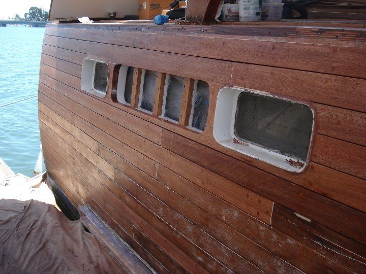 The side of a wooden boat with holes in it
