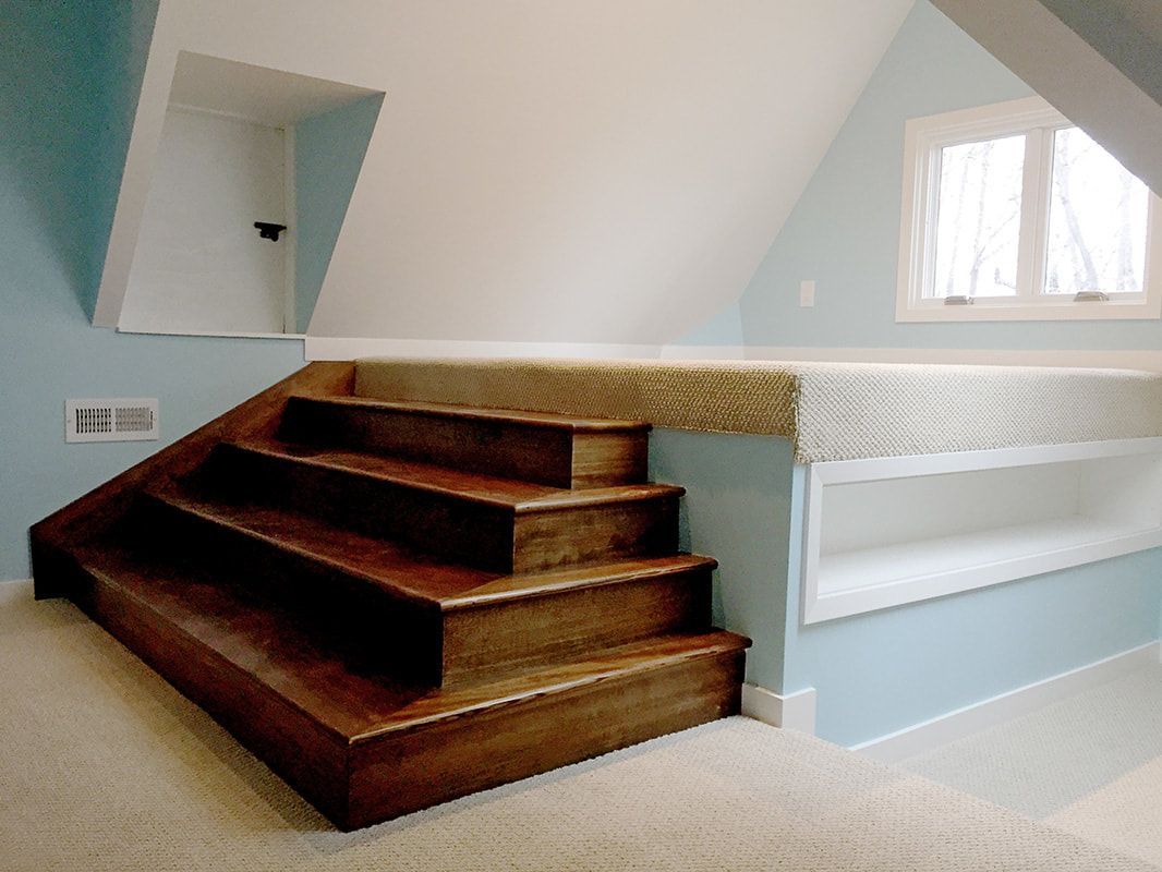 A bedroom with stairs leading up to a bed
