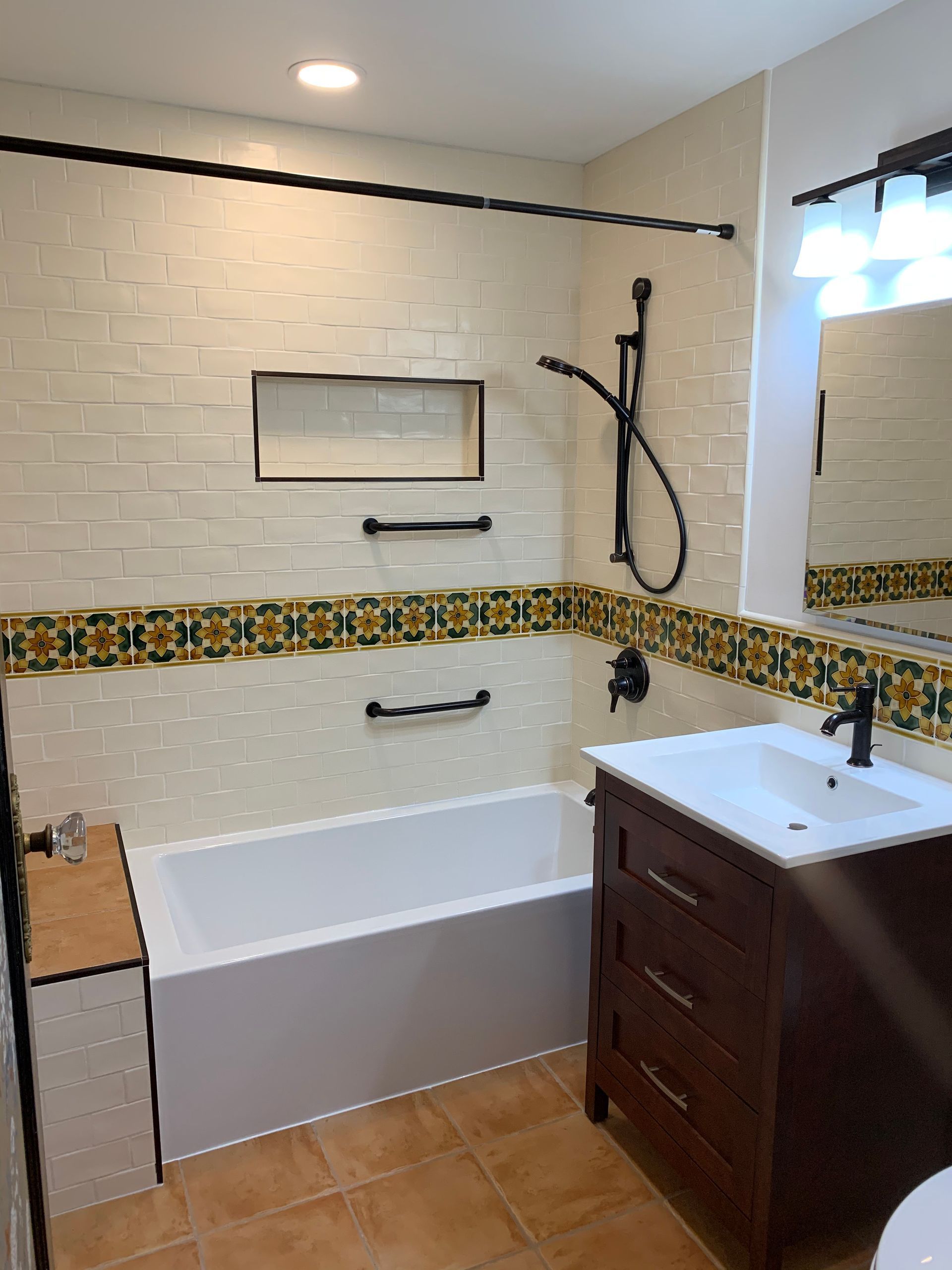 A bathroom with a toilet , sink , mirror and walk in shower.